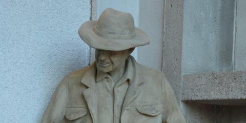 Kopf und Teil des Oberkörpers einer Betonfigur mit Hut